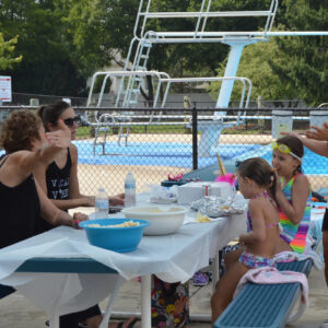 People at a picnic table during a birthday pool party