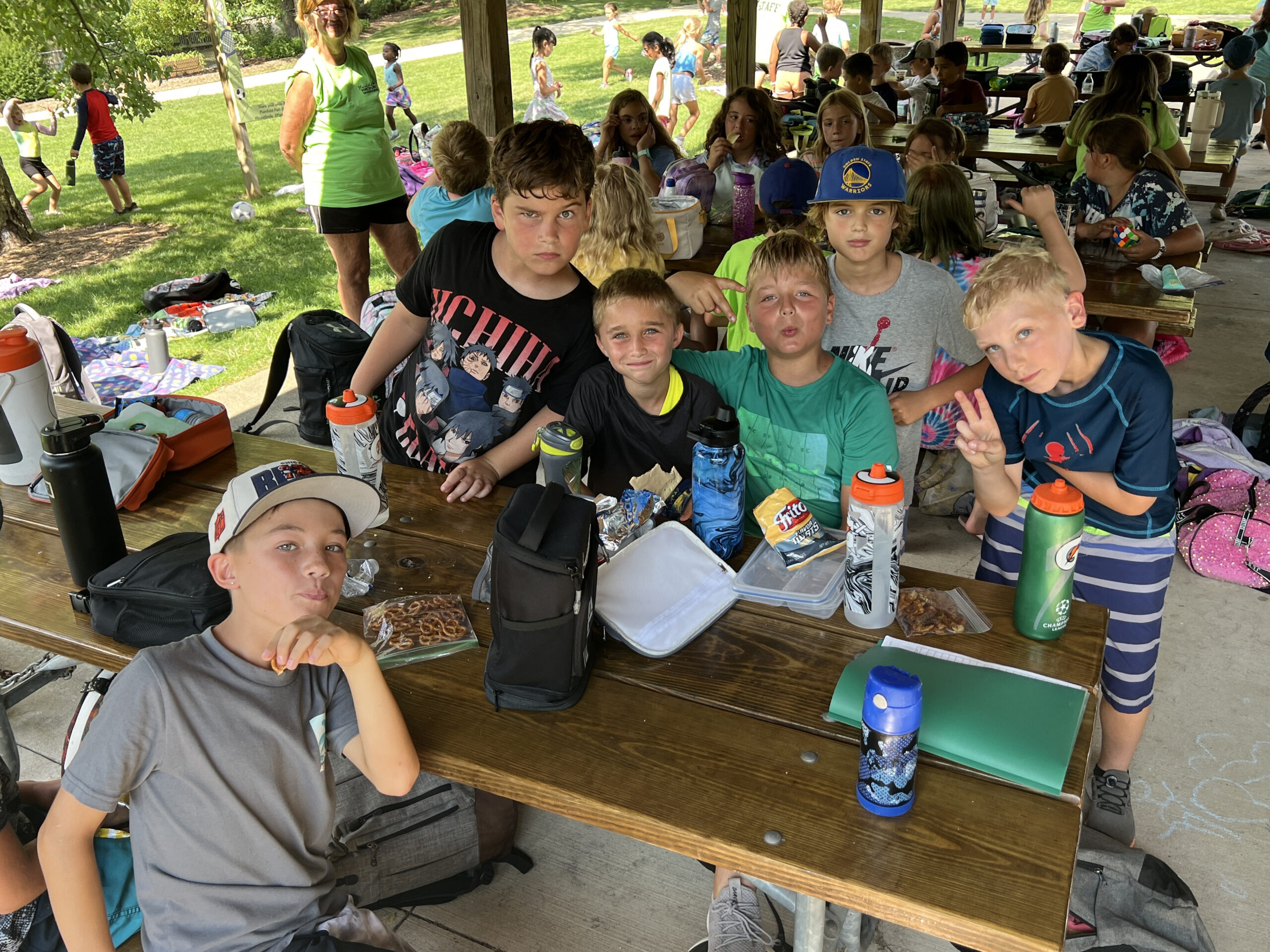Boys at camp eating lunch at a picnic table